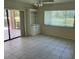 Sunlit living room features tile flooring, a ceiling fan, and sliding glass doors at 3799 Countryside Rd, Sarasota, FL 34233