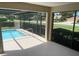 View of screened-in pool area with blue water and lush landscaping, providing a relaxing outdoor space at 3799 Countryside Rd, Sarasota, FL 34233