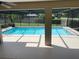 View of a screened-in swimming pool showcasing clear, blue water and a serene backyard setting at 3799 Countryside Rd, Sarasota, FL 34233