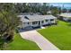 Aerial view of a single-story home with a pool, lush lawn, and a long driveway at 426 S Shore Dr, Sarasota, FL 34234