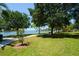 Community green space with lush lawns, mature trees, and benches overlooking the serene waterfront at 426 S Shore Dr, Sarasota, FL 34234