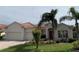 Charming single-story home featuring a well-manicured lawn, mature palm trees, and a terracotta tile roof at 4506 62Nd E Ter, Bradenton, FL 34203