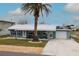Charming single-story home featuring a covered front porch, a garage, and a lush lawn with mature palm tree at 4524 106Th W St, Bradenton, FL 34210