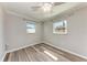 Bright bedroom featuring wood-look floors, a ceiling fan, and two windows at 4550 Ardale St, Sarasota, FL 34232