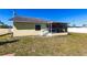 Exterior view of the yellow house with a screened porch and a well-maintained lawn at 4659 Alligator Dr, Venice, FL 34293