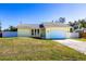 Charming single-story home with a well-maintained lawn and two-car garage, freshly painted in a sunny yellow hue at 4659 Alligator Dr, Venice, FL 34293
