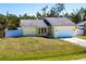 A bright yellow house with a well-manicured lawn, a white garage door, and several windows at 4659 Alligator Dr, Venice, FL 34293