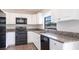 Contemporary kitchen featuring granite countertops, stainless steel appliances, white cabinetry, and laminate flooring at 4659 Alligator Dr, Venice, FL 34293