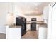 Modern kitchen with white cabinets, granite countertops, stainless steel appliances, and sleek laminate flooring throughout at 4659 Alligator Dr, Venice, FL 34293