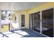 Inside view of the screened porch with a doorway and sliding glass doors into the yellow house at 4659 Alligator Dr, Venice, FL 34293