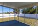 Screened porch with a view of the backyard, trees, and a white fence on a sunny day at 4659 Alligator Dr, Venice, FL 34293