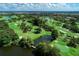 Expansive aerial view of the golf course featuring lush greens, mature trees, serene lakes, and manicured fairways at 5 Barbados Rd # 31, Englewood, FL 34223