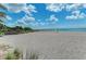 Expansive beach view with volleyball net and blue skies offers a serene and active coastal lifestyle at 5 Barbados Rd # 31, Englewood, FL 34223