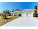Home with a two-car garage, a concrete driveway, and a neatly manicured lawn at 5 Barbados Rd # 31, Englewood, FL 34223