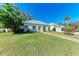 Well-maintained home with lush green lawn, mature trees, and a light-yellow exterior at 5 Barbados Rd # 31, Englewood, FL 34223