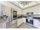 Bright kitchen with stainless steel appliances, white cabinets, and granite countertops at 5 Barbados Rd # 31, Englewood, FL 34223