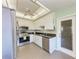 Well-lit kitchen with stainless steel appliances, granite countertops, and white cabinetry at 5 Barbados Rd # 31, Englewood, FL 34223