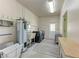 Bright laundry room features washer, dryer, water heater, utility sink and exterior access at 5 Barbados Rd # 31, Englewood, FL 34223