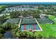 Aerial view showcases tennis and pickleball courts surrounded by lush greenery, offering a vibrant recreational space at 5 Barbados Rd # 31, Englewood, FL 34223
