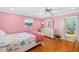 Cozy bedroom featuring a pink accent wall and hardwood floors at 503 Roberts Bay Dr, Nokomis, FL 34275