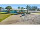 Inviting turquoise home featuring palm trees, fresh landscaping, and a driveway in the front at 503 Roberts Bay Dr, Nokomis, FL 34275