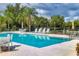Community pool surrounded by a black fence, lounge chairs and plenty of greenery at 5234 Aqua Breeze Dr, Bradenton, FL 34208