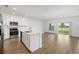 Open-concept kitchen flowing into a living area, featuring a kitchen island and stainless appliances at 5533 Patano Loop, Palmetto, FL 34221