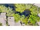 Aerial view of the property and surrounding area showcasing lush greenery and a tranquil pond at 5655 Pipers Waite # 27, Sarasota, FL 34235