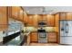 Kitchen featuring wood cabinets, granite countertops, and stainless steel appliances at 5655 Pipers Waite # 27, Sarasota, FL 34235