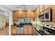 Kitchen featuring wood cabinets, granite countertops, and stainless steel appliances at 5655 Pipers Waite # 27, Sarasota, FL 34235