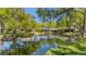 Scenic view of a community pond reflecting the surrounding trees and homes at 5655 Pipers Waite # 27, Sarasota, FL 34235