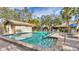 Beautiful community pool with a spa, surrounded by brick pavers and tropical landscaping at 5655 Pipers Waite # 27, Sarasota, FL 34235