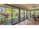 Bright sunroom with tile floors, ceiling fan and large sliding windows overlooking the pond at 5655 Pipers Waite # 27, Sarasota, FL 34235