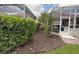 View of the backyard with a screened-in patio and lush landscaping for added privacy at 5962 Roseto Pl, Sarasota, FL 34238