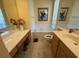 Bright bathroom features a tub, painting, and dual vanity with wood cabinets at 5962 Roseto Pl, Sarasota, FL 34238