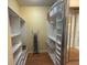Walk-in closet with custom shelving, hanging racks, and an ironing board at 5962 Roseto Pl, Sarasota, FL 34238
