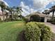 Exterior view of the home with a well-manicured lawn, mature trees, and a two-car garage at 5962 Roseto Pl, Sarasota, FL 34238
