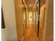 Hallway with mirrored closet doors and wood floors leading to other rooms at 5962 Roseto Pl, Sarasota, FL 34238
