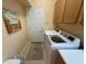 Laundry room including washer, dryer, storage cabinets, and door to the exterior at 5962 Roseto Pl, Sarasota, FL 34238