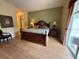 Spacious main bedroom featuring wood floors, a king bed, and ensuite bathroom access at 5962 Roseto Pl, Sarasota, FL 34238