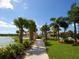 Picturesque path in the community with lush landscaping, benches, and a view of the lake at 5962 Roseto Pl, Sarasota, FL 34238