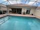 Backyard view of a screened pool with a covered patio and grill, ideal for outdoor living at 5962 Roseto Pl, Sarasota, FL 34238