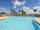 Large community pool surrounded by palm trees and lounge chairs for relaxing recreation at 5962 Roseto Pl, Sarasota, FL 34238