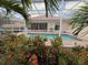 Serene view of a screened pool surrounded by lush landscaping, offering a private backyard oasis at 5962 Roseto Pl, Sarasota, FL 34238