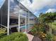 View of the screened pool from the yard with landscaped greenery, adding privacy and beauty at 5962 Roseto Pl, Sarasota, FL 34238
