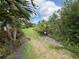 Landscaped grassy backyard with bushes and trees, a private outdoor space at 5962 Roseto Pl, Sarasota, FL 34238