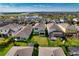 An aerial view of a neighborhood and home near a pond and sports field in Florida at 6136 Voyagers Pl, Apollo Beach, FL 33572
