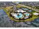 Overhead view of community center, showcasing pools, tennis courts, and recreational areas nestled by a serene lake at 6136 Voyagers Pl, Apollo Beach, FL 33572
