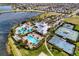 Aerial view of a luxurious community pool and amenity center with tennis courts, playgrounds, and landscaped surroundings at 6136 Voyagers Pl, Apollo Beach, FL 33572