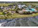 An aerial shot showcasing a community center with pools, playground, tennis courts, and scenic water views at 6136 Voyagers Pl, Apollo Beach, FL 33572